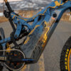 A close up of the painted frame on an Optibike E-Bike, showing the hand painted wolf howling at the sky, painted in vibrant gold color.