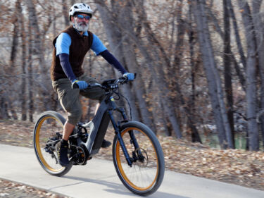Rider testing the high-speed capability of the Optibike Metro electric street bike on a bike path.